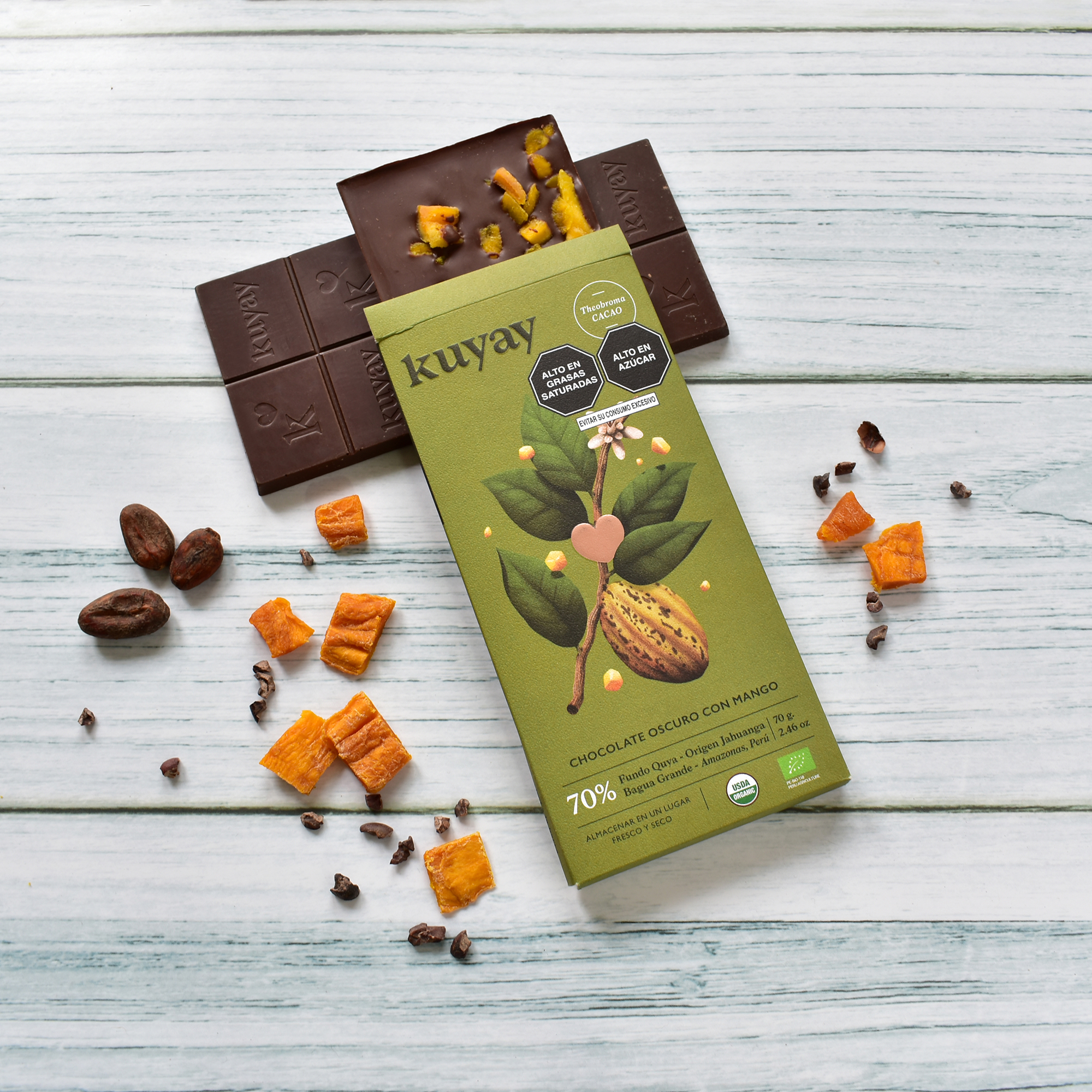 Kuyay mango bar with dried mango pieces and cacao nibs on white wood