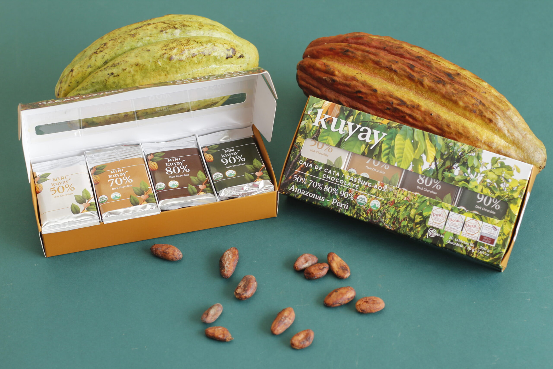 Kuyay tasting box open and closed on a green backdrop with cacao beans